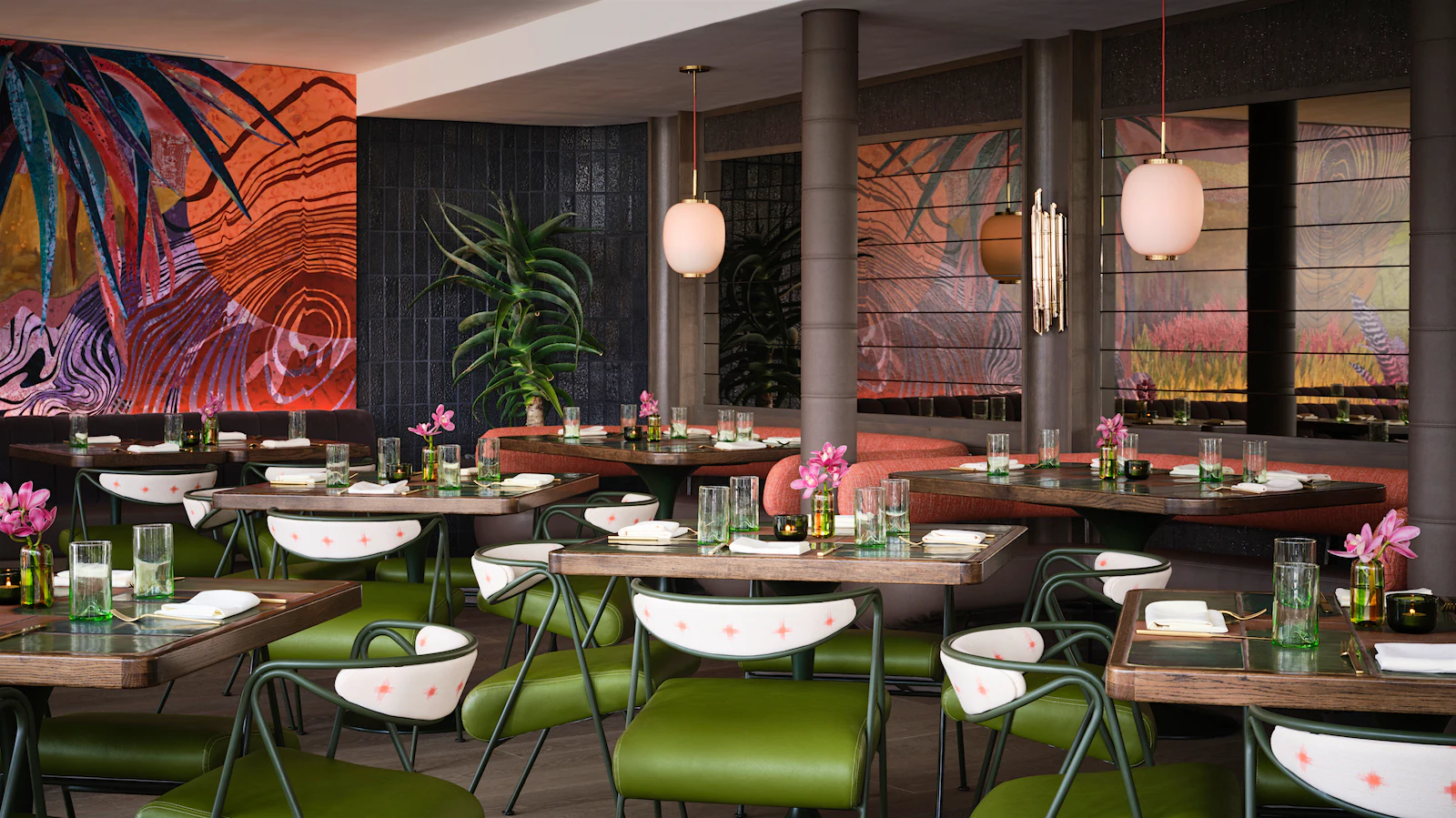 The dining room at Paradiaea with a green color scheme and tropical murals on the wall.